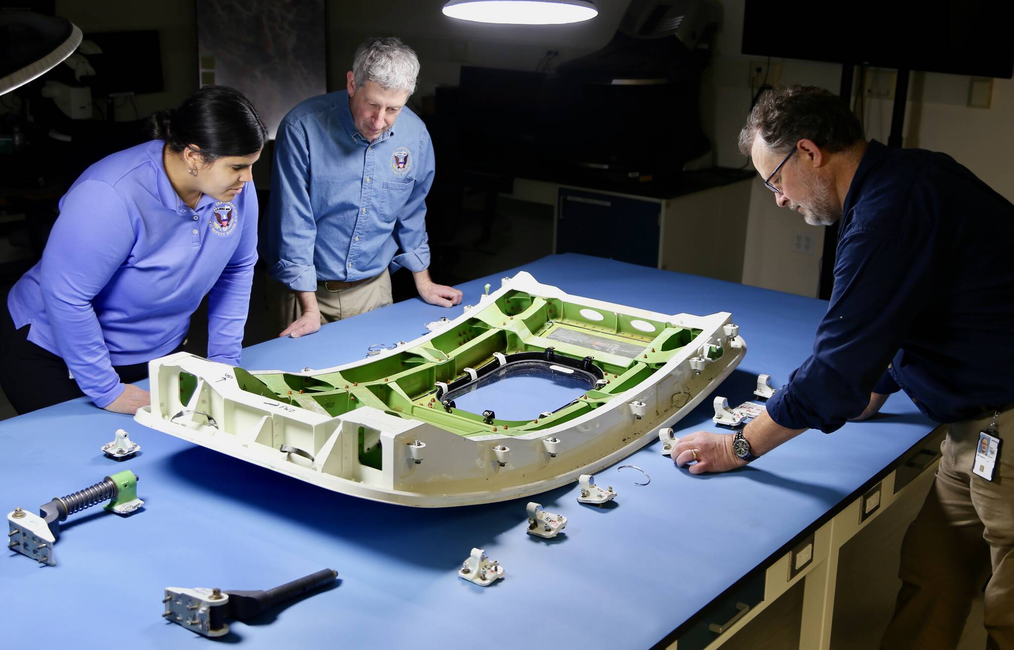 NTSB investigators examine the MED plug from Alaska Airlines flight 1282. (Photo courtesy of National Transportation Safety Board)