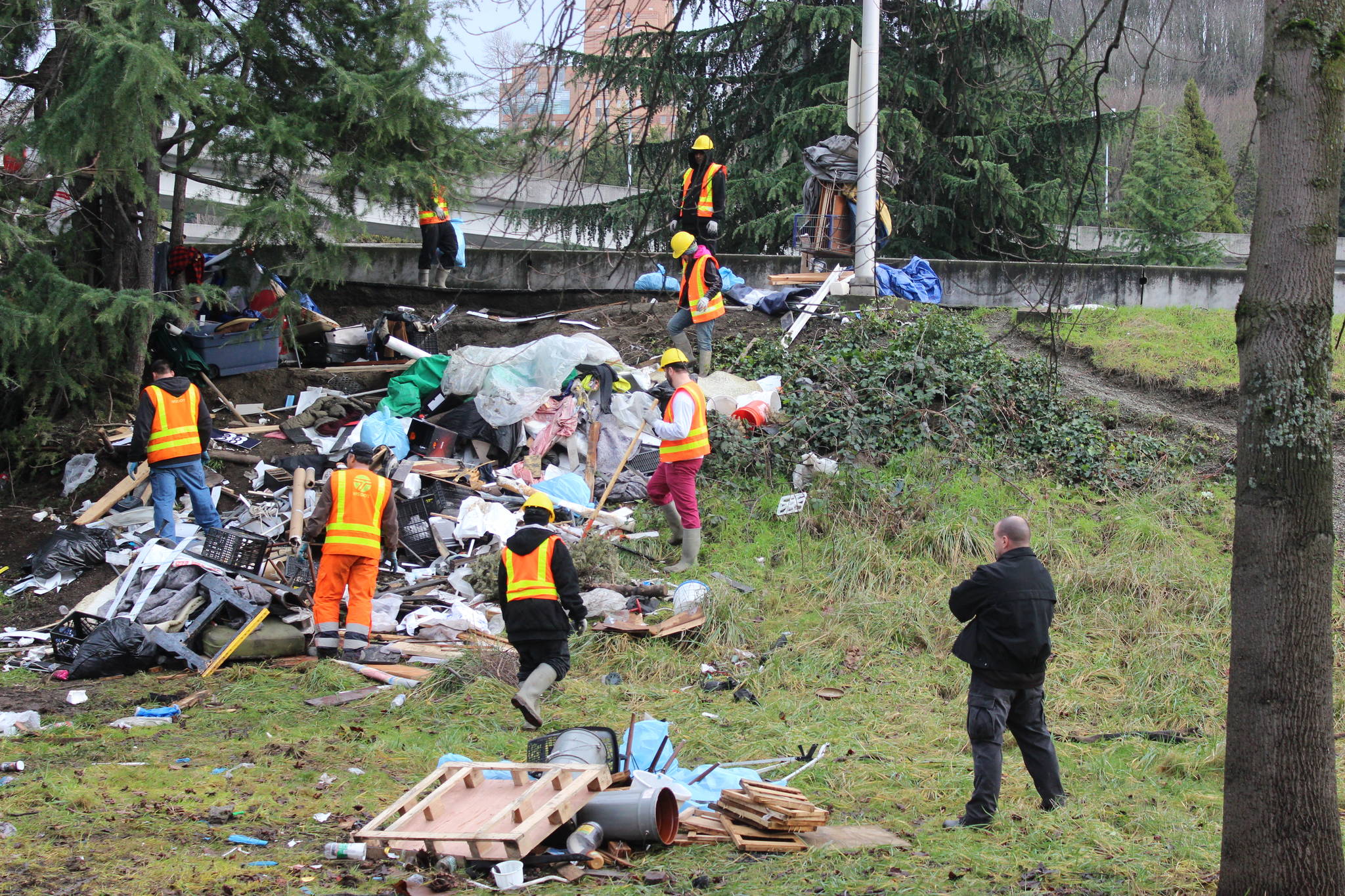 Prisoners clean up trash at ‘the Field,’ an encampment that Seattle authorities destroyed, and later re-created and then re-destroyed, while Scott Lindsay was managing sweeps for Mayor Ed Murray. Photo by Casey Jaywork