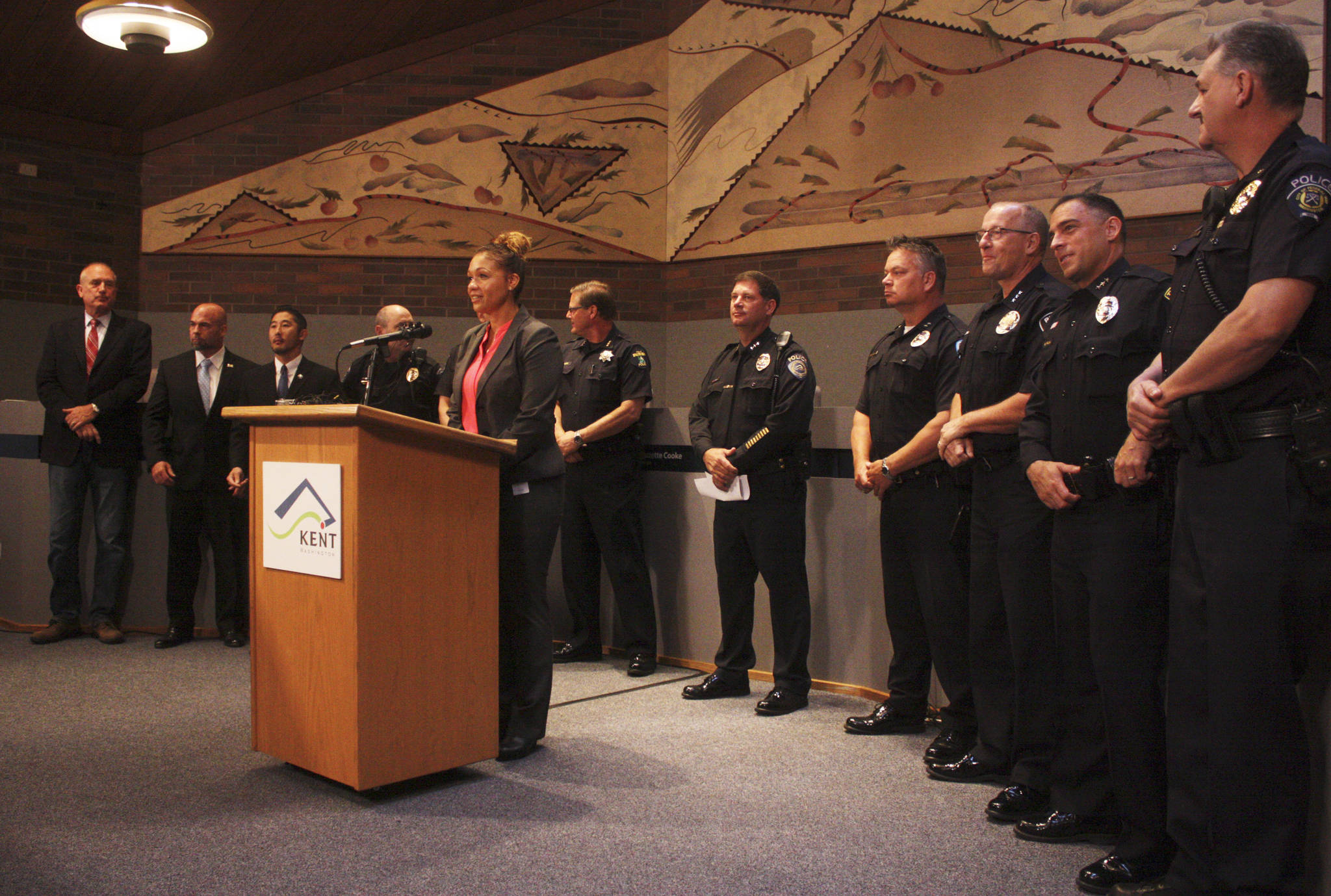 Kent Police spokeswoman Melanie Robinson on Monday at Kent City Hall surrounded by representatives from law enforcement agencies across South King County. Photo by Mark Klaas/Kent Reporter